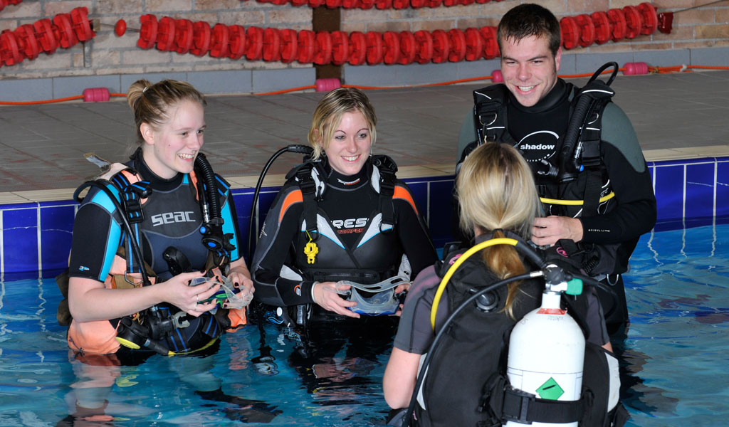 Diving instructor with students in pool