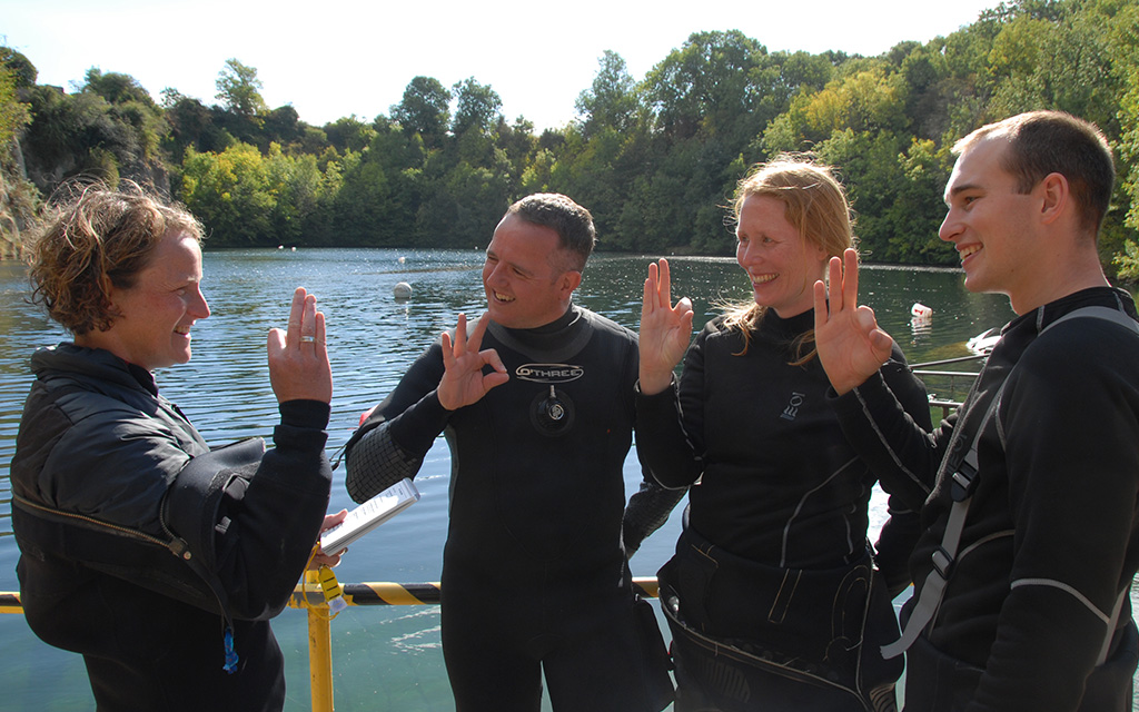 Instructor and trainees signalling ok topside