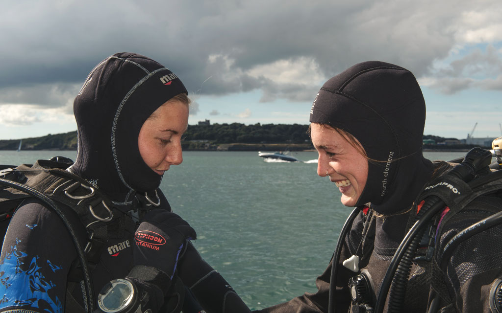 2 BSAC divers in full kit performing an equipment check