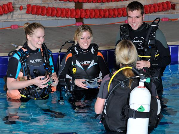 Diving instructor with students in pool