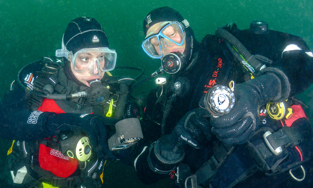 Divers using a compass underwater