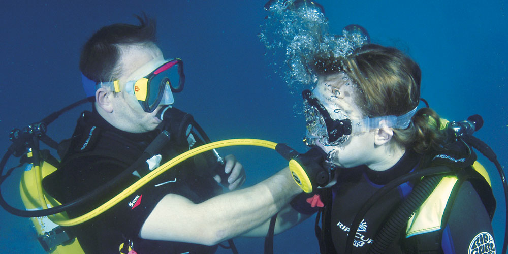 Scuba diving instructor doing refresher skills in the pool
