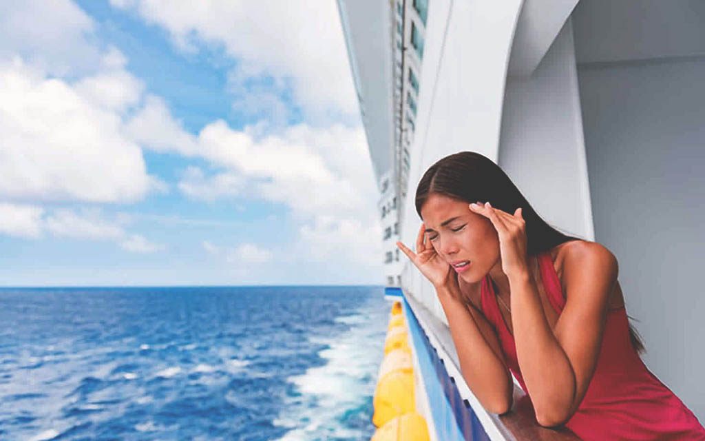 woman on the lower deck of a ship with a migraine