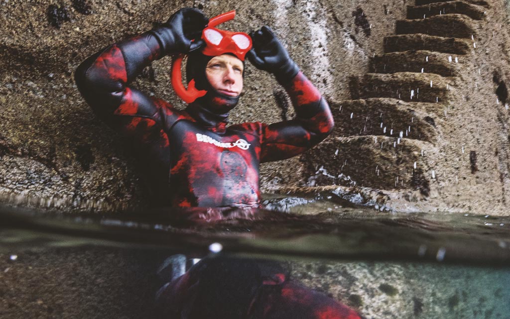 Andy Torbet half submerged, in snorkelling gear, ready for a dive