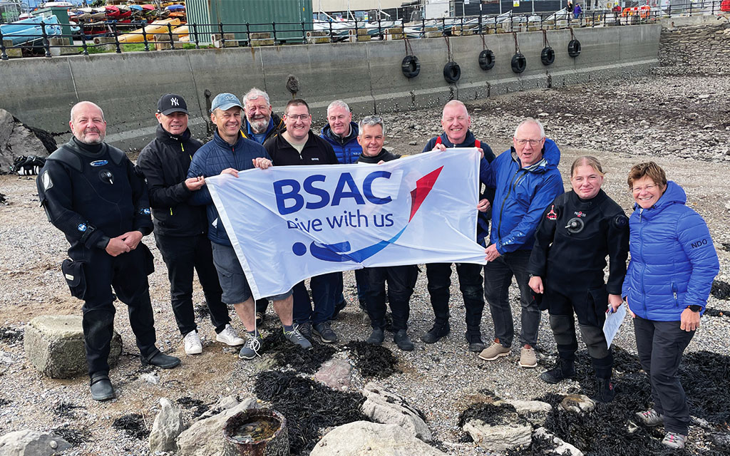 The candidates and team flying the BSAC banner after a successful examination