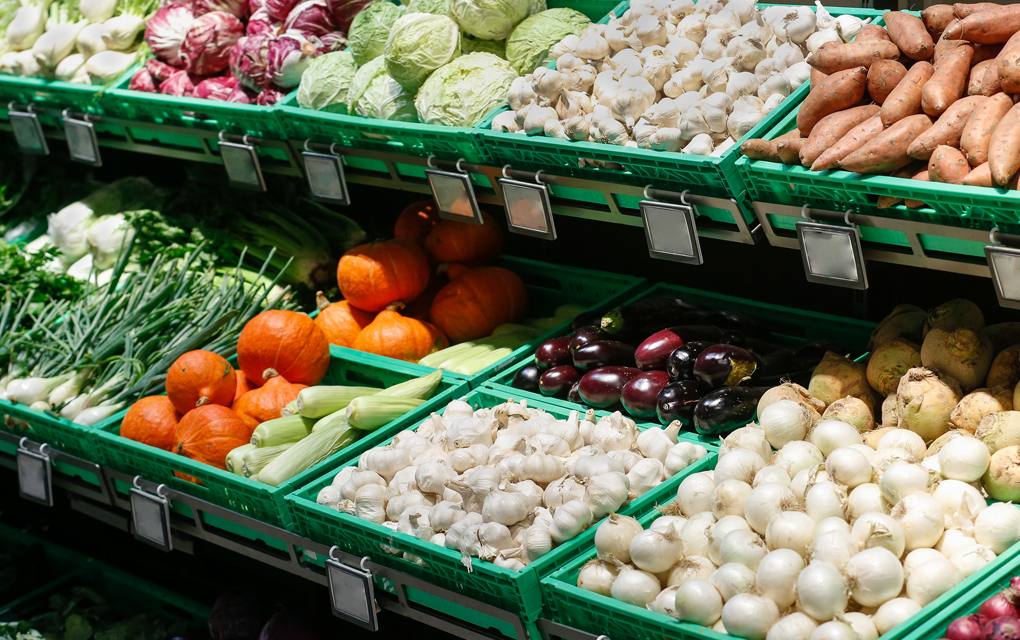 Vegetables in a greengrocer, stacked instead of individually wrapped in plastic. Cabbages, garlic, sweet potato, spring onion, pumpkin, aubergine.