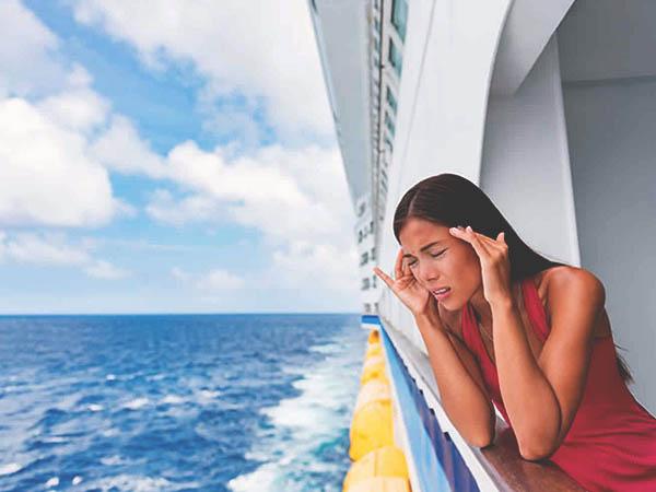 woman on the lower deck of a ship with a migraine