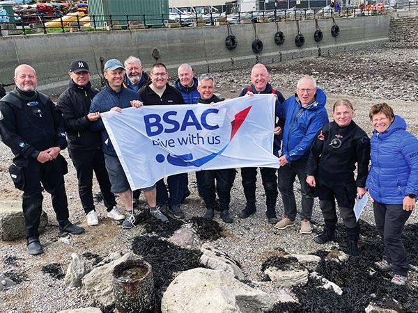 The candidates and team flying the BSAC banner after a successful examination
