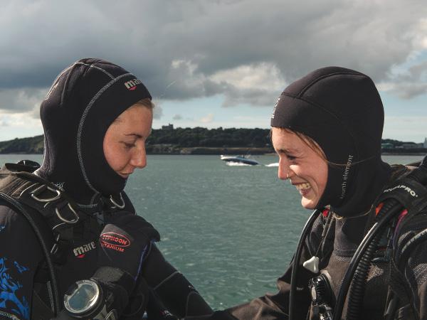 2 BSAC divers in full kit performing an equipment check