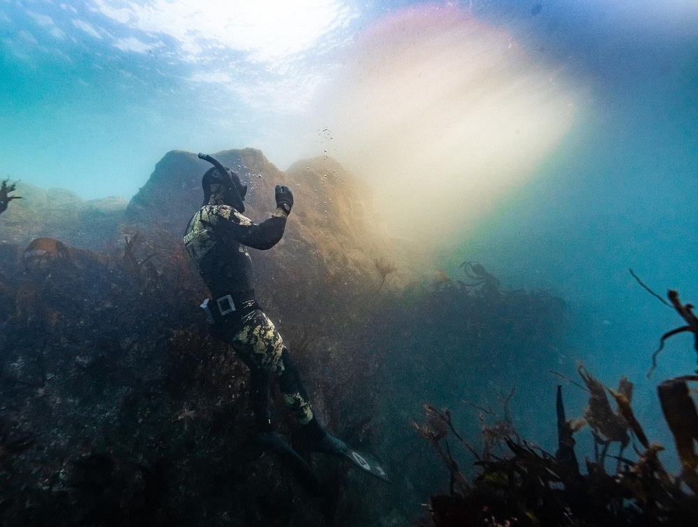 Andy Torbet floating in a shaft of sunlight underwater