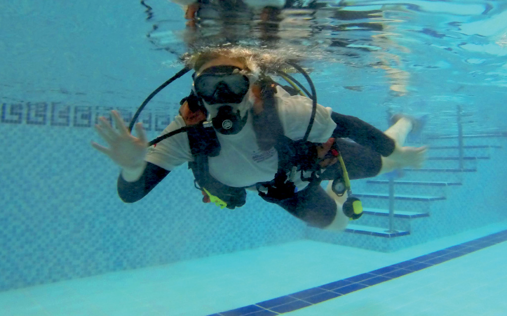 person scuba diving underwater in a pool during trydive