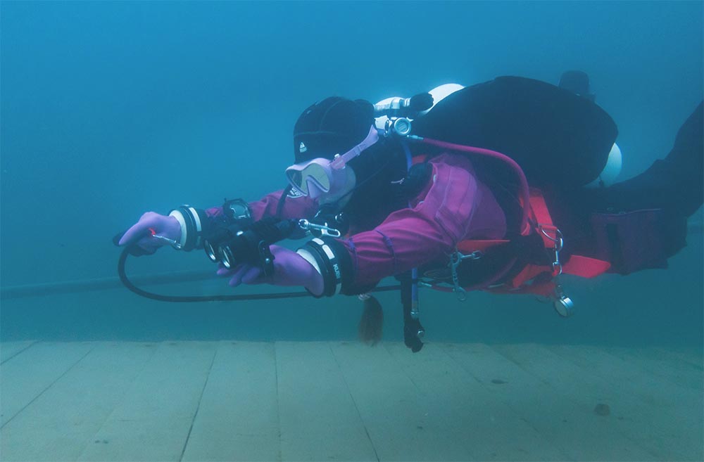 Aithne Atkinson underwater in full kit, demonstrating primary donate technique