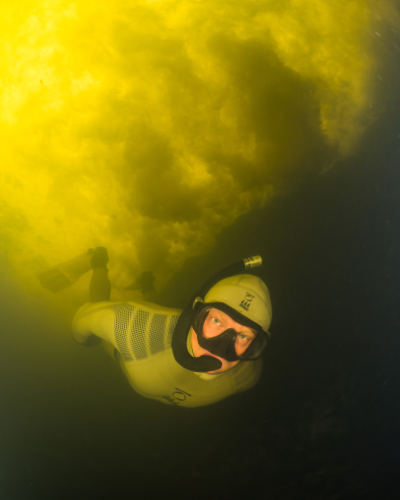 Andy Torbet snorkelling in seemingly bright yellow water.