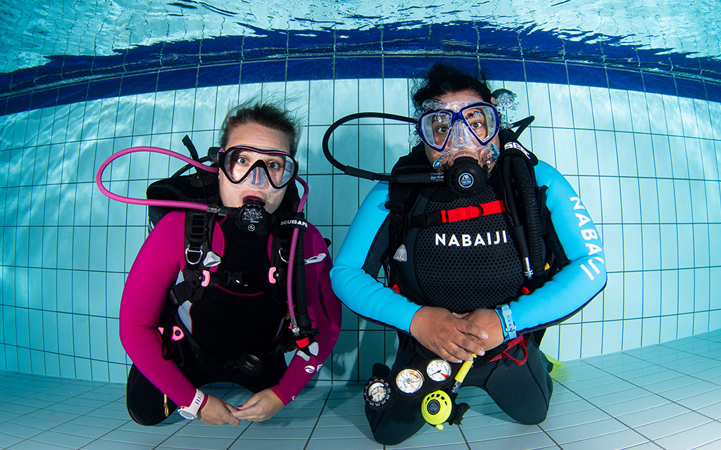 2 People in the swimming pool learning to dive