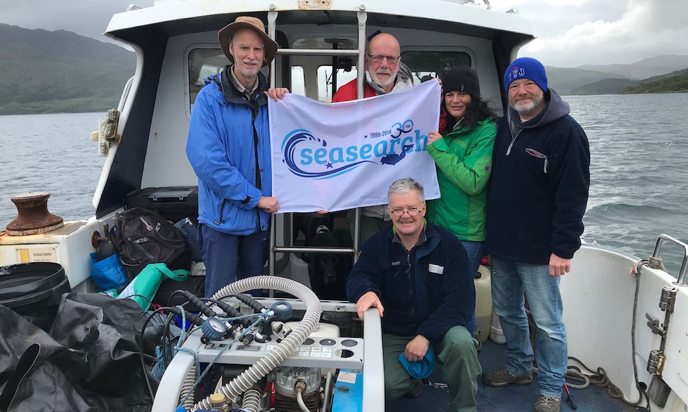 Bingham divers on a boat holding a Seasearch banner