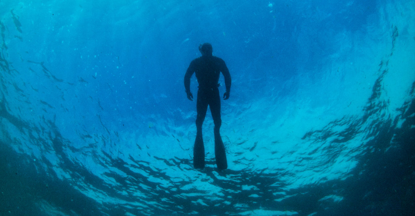 Looking up at a snorkelled in clear blue water