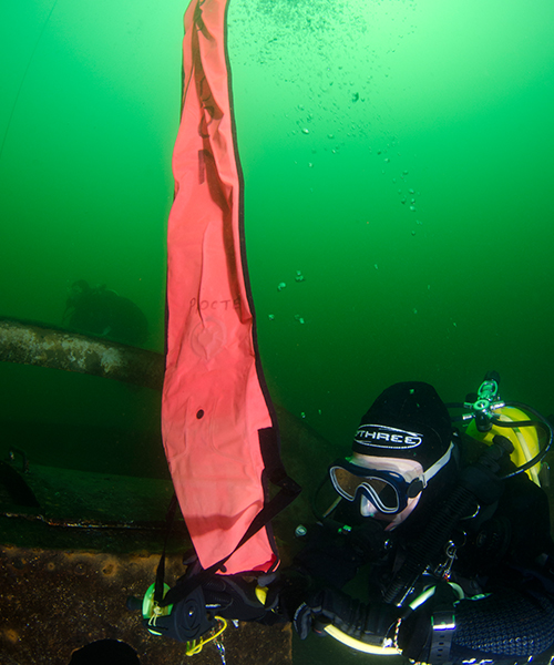 Diver deploys a DSMB at depth