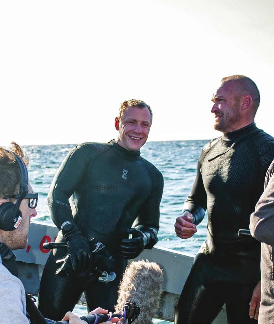 Andy Torbet smiling on a boat with a film crew