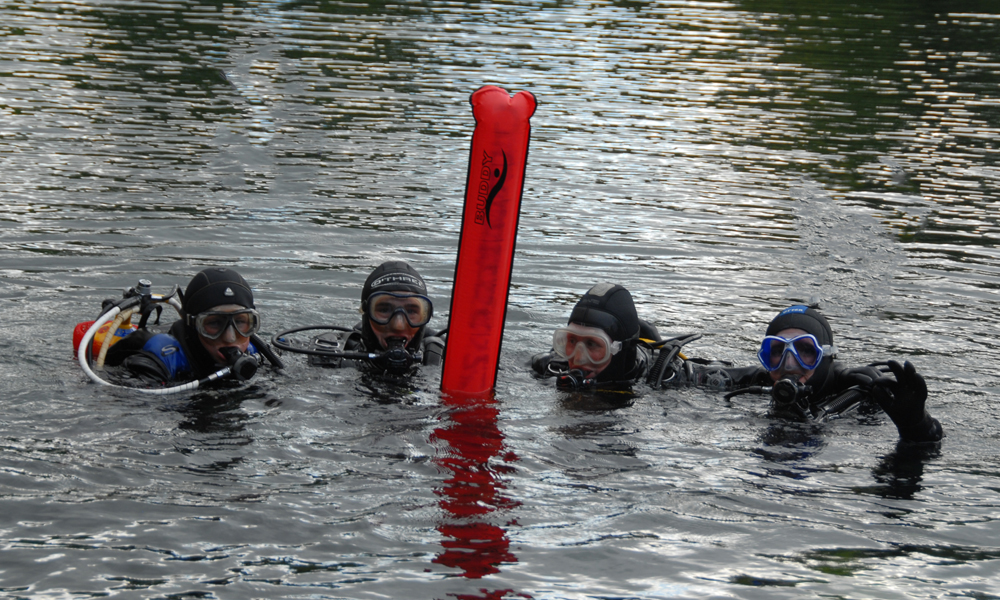 Divers with marker buoy at surface