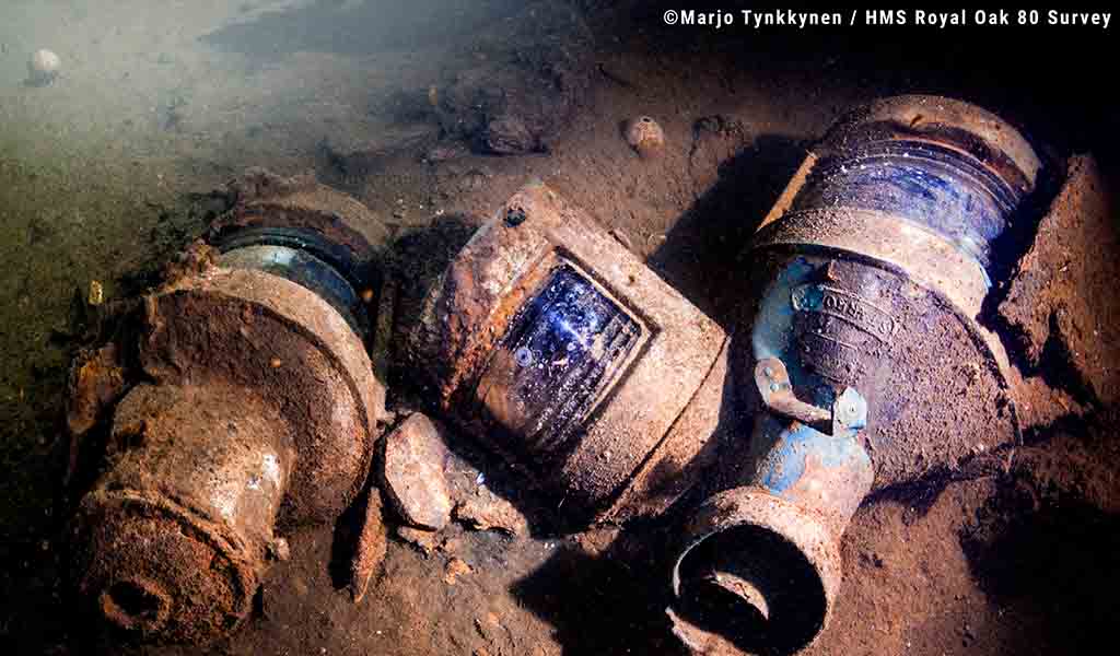 Ship's lamps sit on the seabed underneath the ship