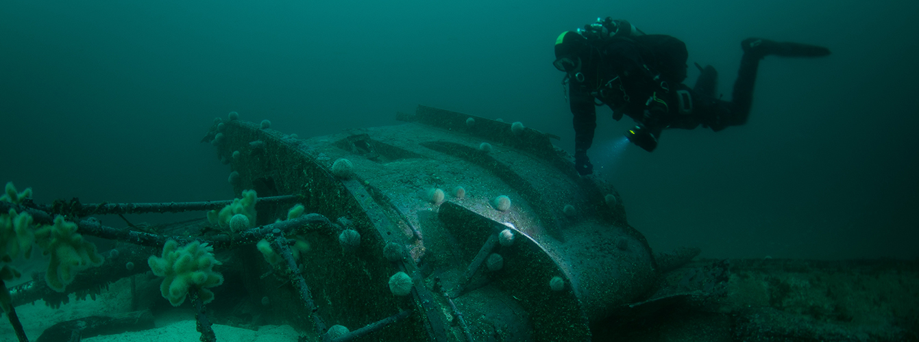 Diver above a wreck scuttled on the sea bed